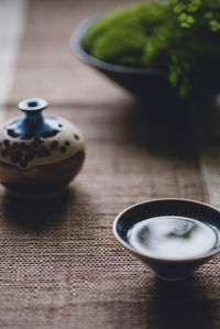 High angle view of herbal tea in tenmoku on place mat