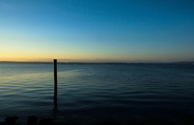 Scenic view of sea against clear sky during sunset