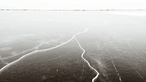 Aerial view of landscape by sea against sky