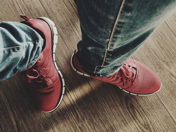 Low section of man standing on hardwood floor