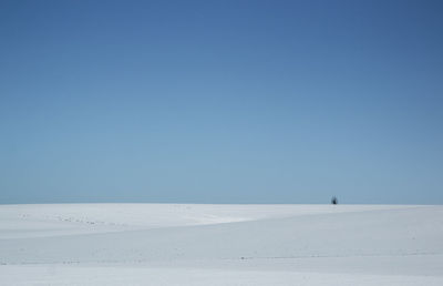 Scenic view of snowy landscape against clear blue sky