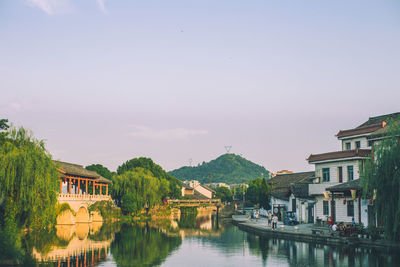 River amidst houses and buildings against sky