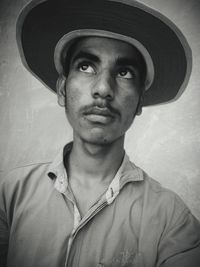 Thoughtful man wearing hat looking away outdoors