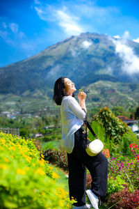 Side view of woman standing on mountain