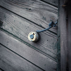 An old doorbell button on the wooden wall