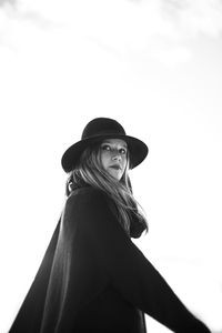 Portrait of young woman wearing hat against white background