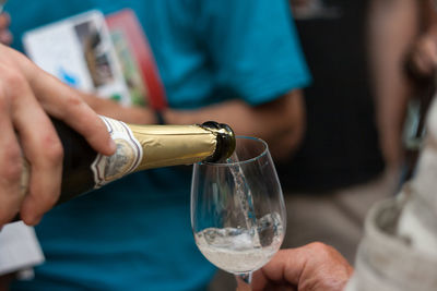 Close-up of hand pouring wine in glass