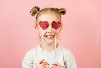 Portrait of young woman wearing mask against yellow background