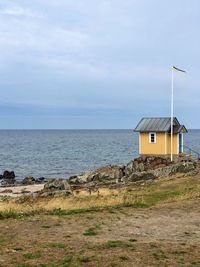 Built structure on beach by sea against sky