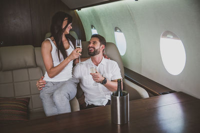 Couple drinking champagne in corporate jet