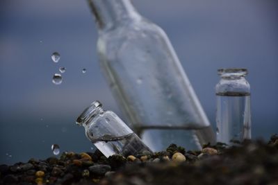 Close-up of bottles on rocks at beach