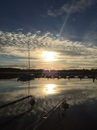 Silhouette boats moored in lake against sky during sunset