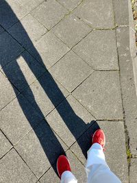 Low section of person standing on footpath