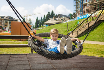 Portrait of boy lying on play equipment at playground