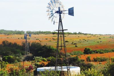 Windmill on field against clear sky