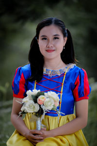 Portrait of young woman sitting on field