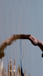 Person dipping hand in water at beach