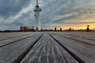 Surface level of pier against sky at sunset
