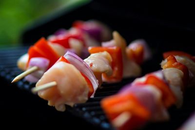 Close-up of prawns and vegetables in skewers on barbecue grill