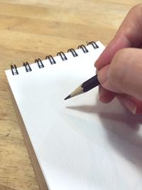 High angle view of hand writing book at table