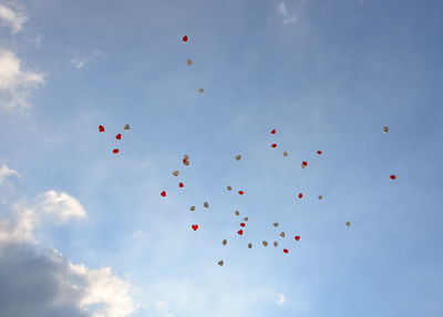 Low angle view of balloons flying against sky