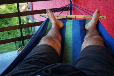 Low section of man relaxing on hammock