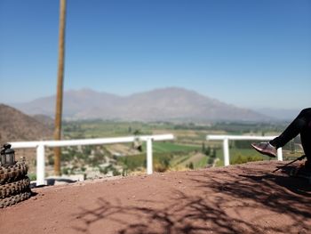 Man on arid landscape against clear sky