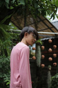 Side view of woman standing against plants