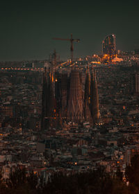 Illuminated buildings in city against sky at night