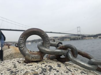 Close-up of chain on bridge against sky