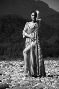 Portrait of young woman standing on rock