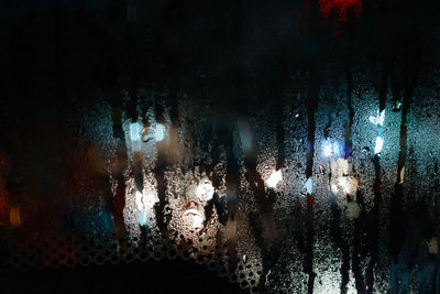 Full frame shot of wet glass window at night