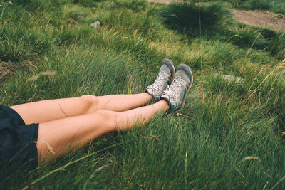 Woman legs on the grass relaxing after hiking