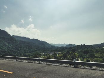 Road by mountains against sky