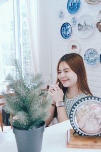 Portrait of young woman sitting on table at cafe