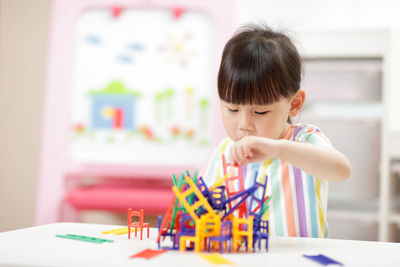 Young girl playing balance chair and ladder toys at home