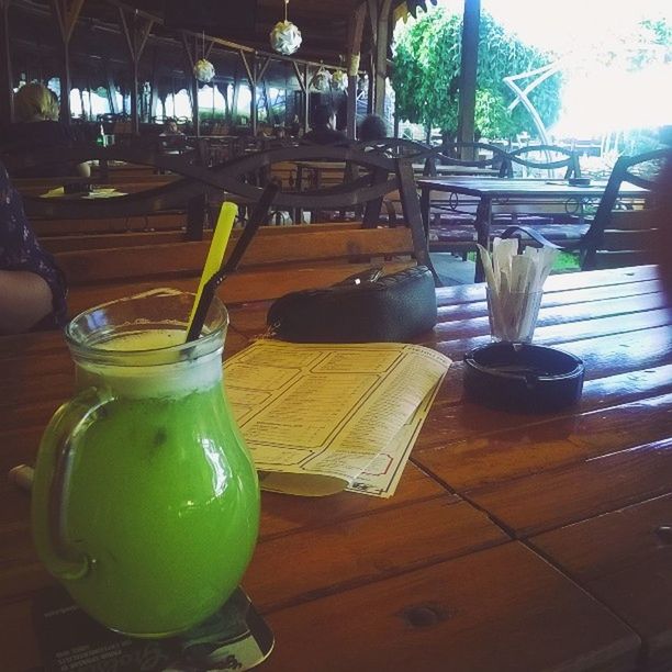 table, food and drink, indoors, chair, drink, restaurant, drinking glass, still life, refreshment, empty, wood - material, freshness, absence, glass - material, food, cafe, day, potted plant, place setting, sunlight