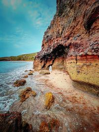 Rock formation in sea against sky