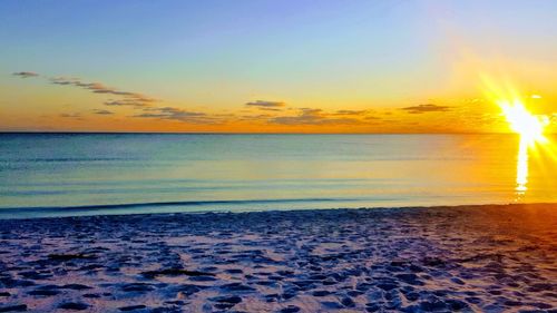 Scenic view of beach against sky during sunset