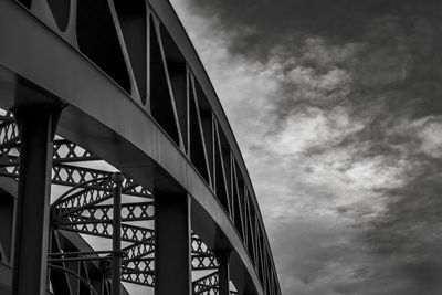 Low angle view of bridge against cloudy sky