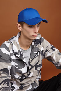 Young man looking away against gray background