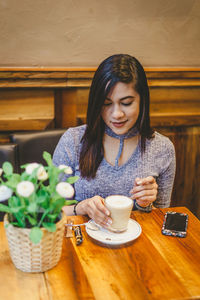 Young woman sitting on table at restaurant