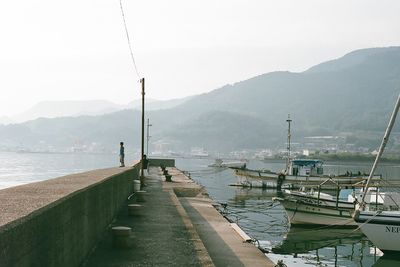 Pier on sea with mountain in background