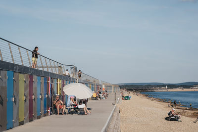 People at beach against sky