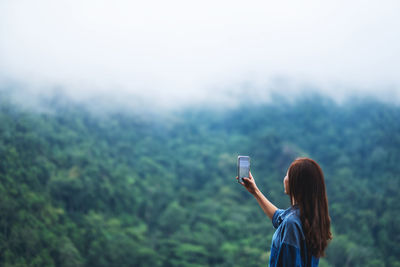 Rear view of woman photographing