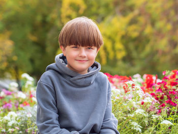 Portrait of boy standing against plants