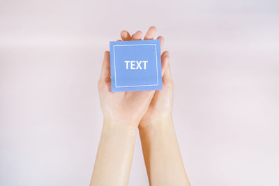 Midsection of person holding text against white background