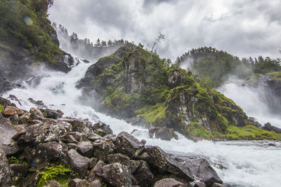 Scenic view of waterfall against sky