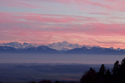 Scenic view of silhouette mountains against romantic sky at sunset