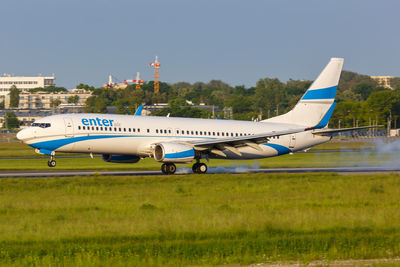 Airplane on airport runway against sky